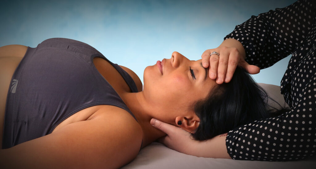 Therapist performing myofascial release on a patient's head and neck